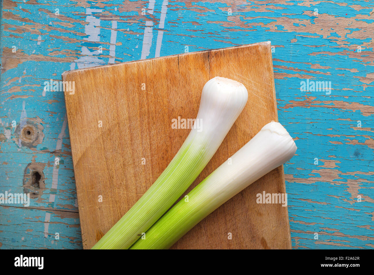 Lauch auf Schneidebrett auf rustikalen Holz Küchentisch, frisches grünes Gemüse für gesunde Ernährung Vorteile, Ansicht von oben Stockfoto
