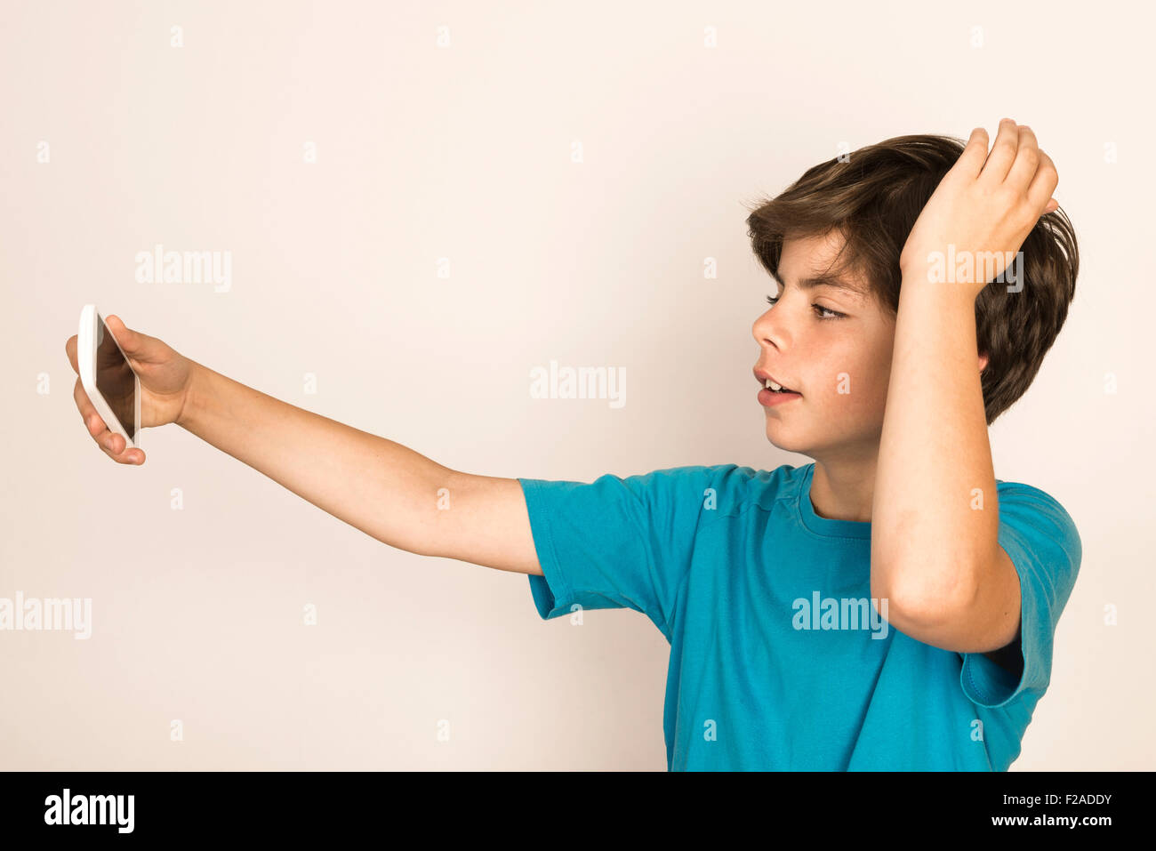 Glückliche junge nehmen ein Selbstporträt mit einem Smartphone zu Hause isoliert auf weißem Hintergrund Stockfoto