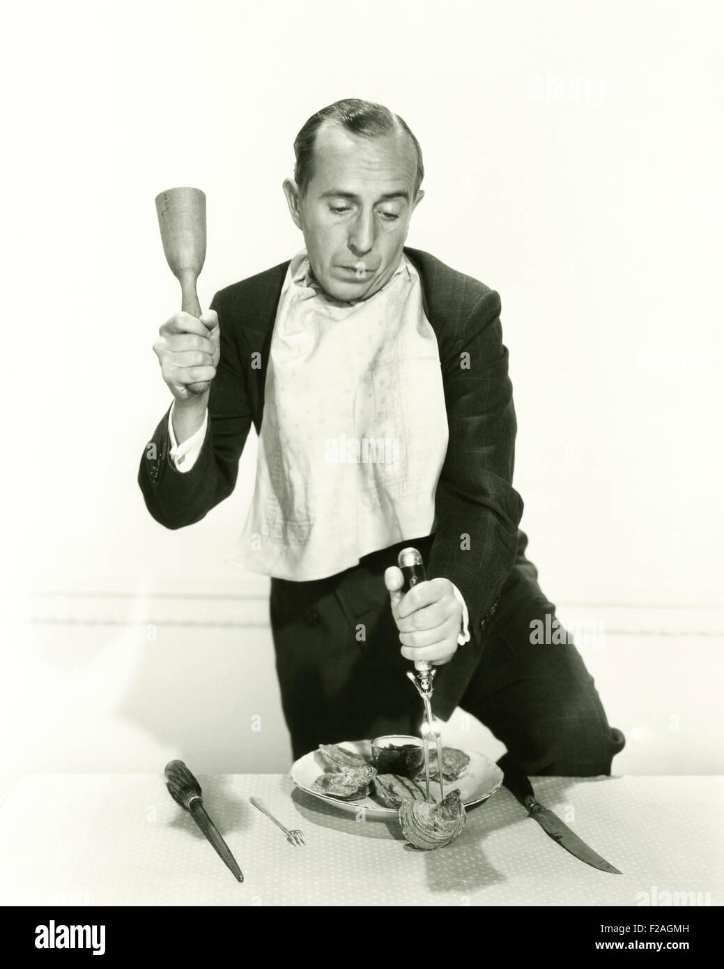 Mann, der versucht zu knacken öffnen Austernschale (OLVI008 OU101 F) Stockfoto