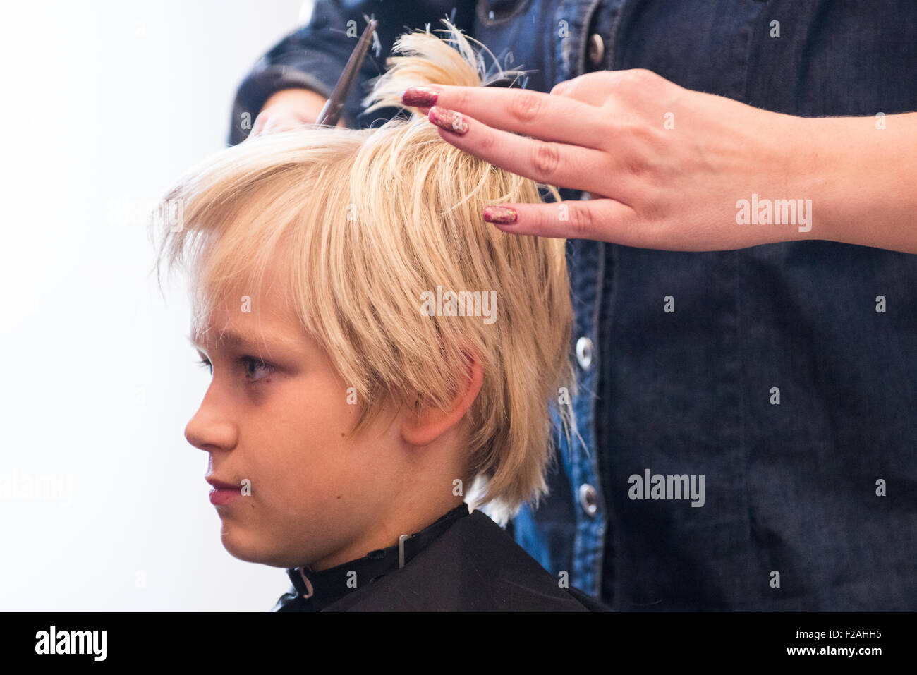 Kind blonde junge bekommen einen Haarschnitt Stockfoto