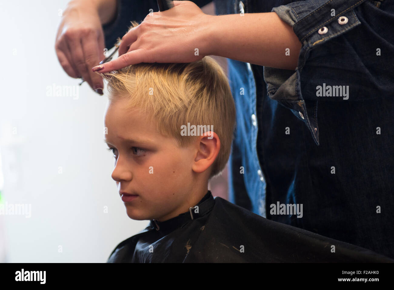 Kind blonde junge bekommen einen Haarschnitt Stockfoto