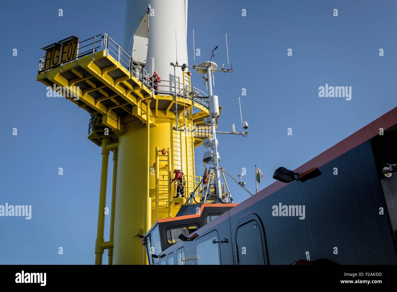 Ingenieure, die Klettern Windkraftanlage vom Boot am Offshore-Windpark Stockfoto