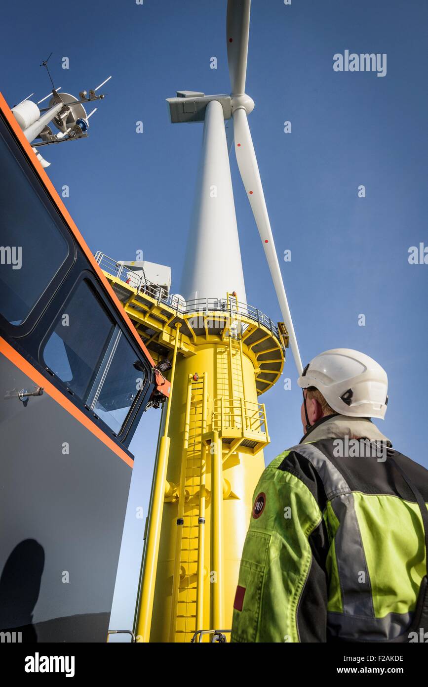 Ingenieure, die Klettern Windkraftanlage vom Boot am Offshore-Windpark, niedrigen Winkel Ansicht Stockfoto