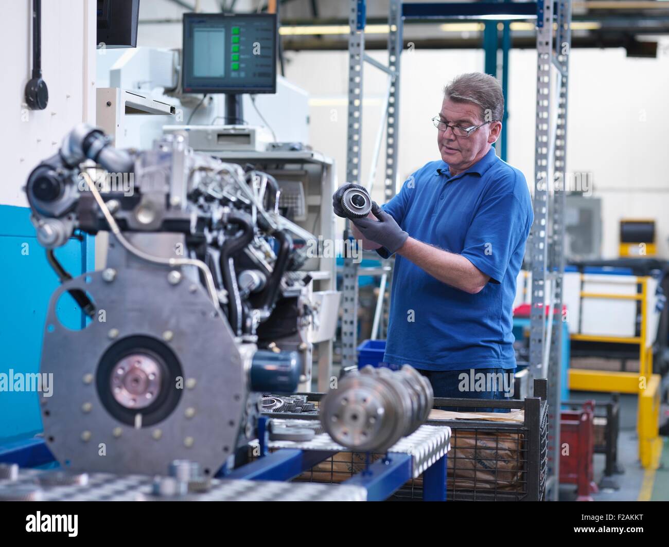 Ingenieur mit Zahnrad und Dieselmotor in engineering Fabrik Stockfoto