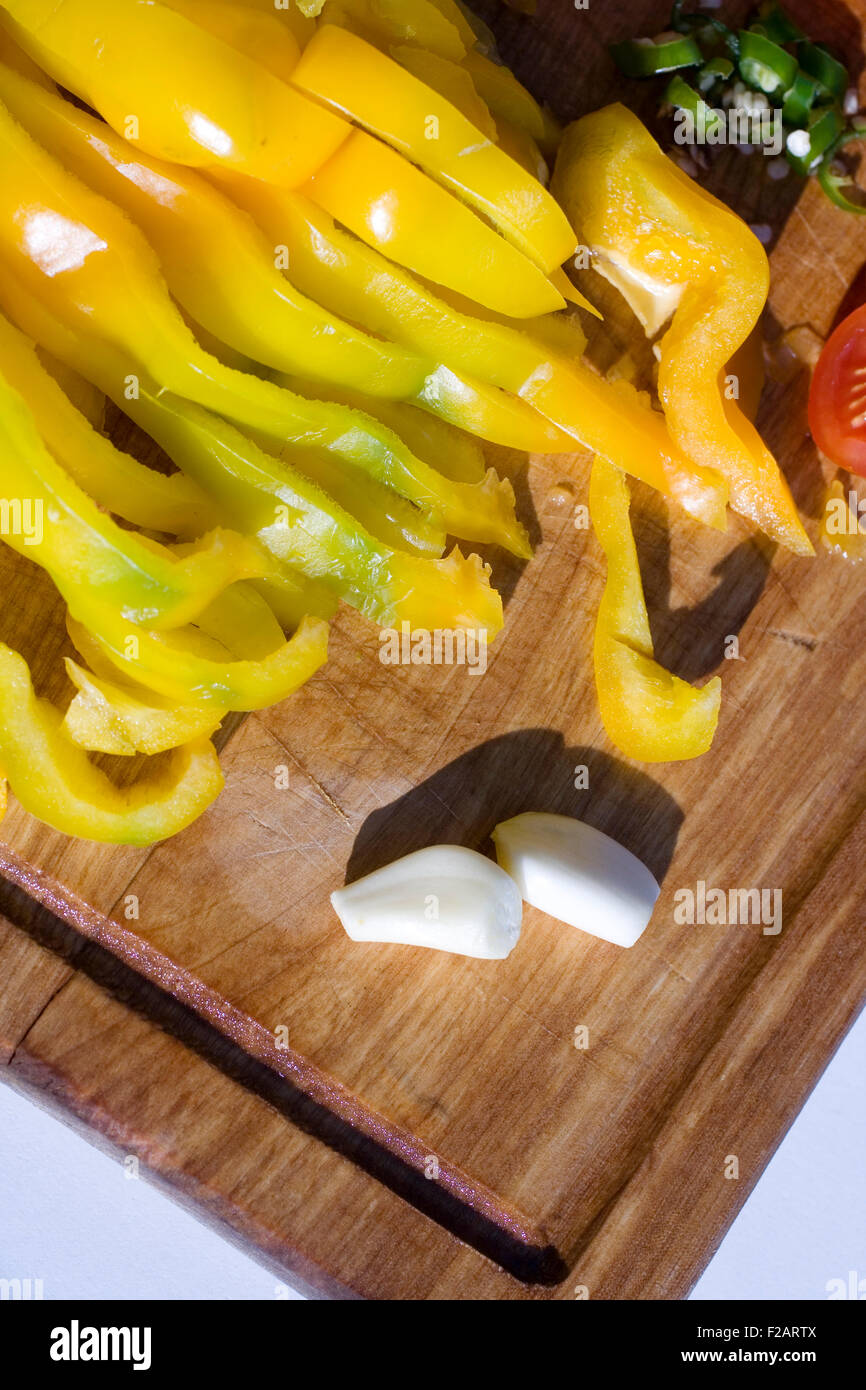 Gelbe geschnittenen Paprika und Knoblauch auf ein Schneidebrett Stockfoto