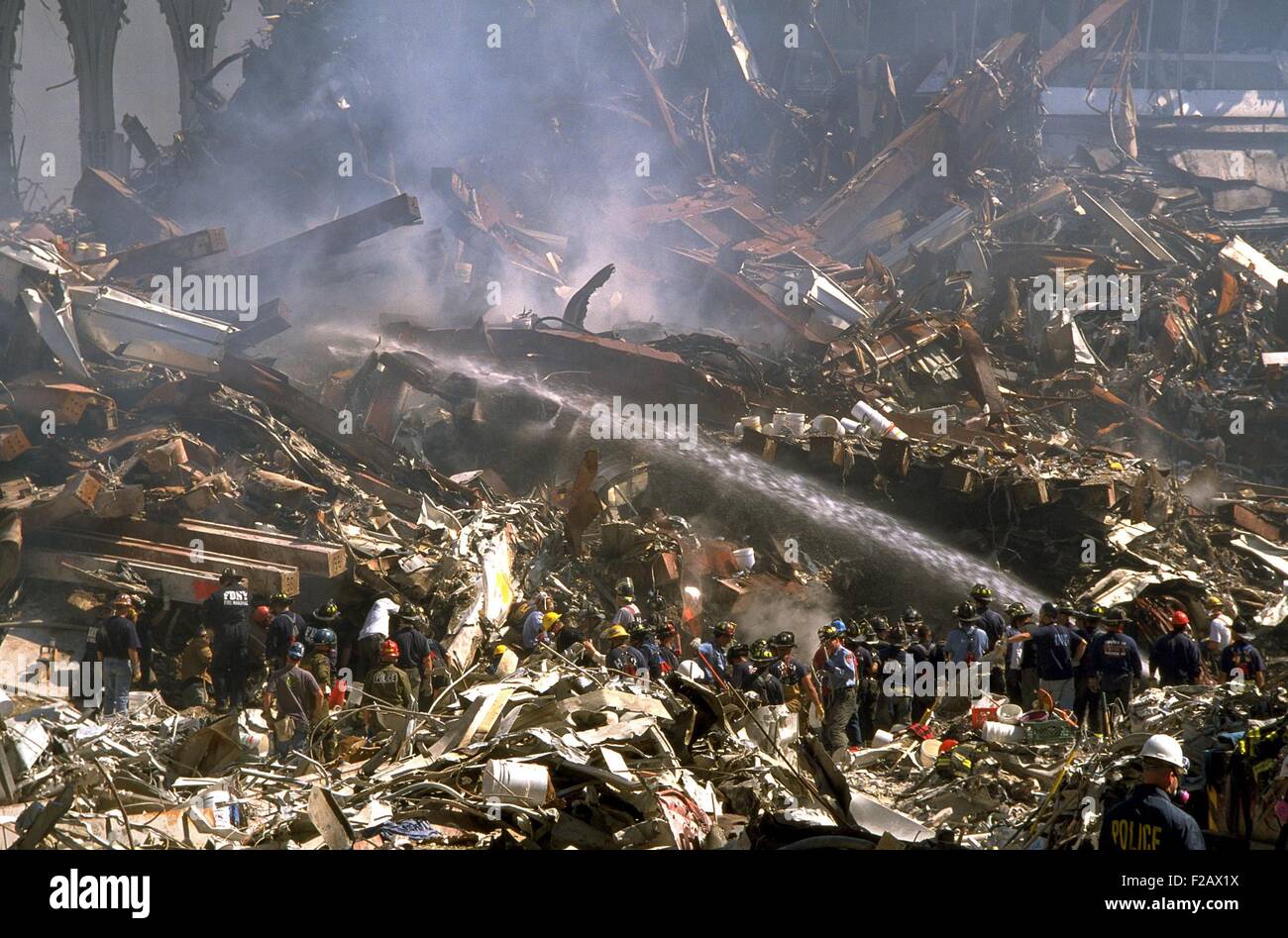 Feuerwehr-Sprays noch brennenden Trümmern des World Trade Centers am 16. September 2001. In der oberen rechten Ecke befinden sich Ruinen von WTC 3, das Marriott World Trade Center, einmal ein 22 Geschichte Hotel. New York City, nach dem 11. September 2001 Terroranschläge. (BSLOC 2015 2 89) Stockfoto