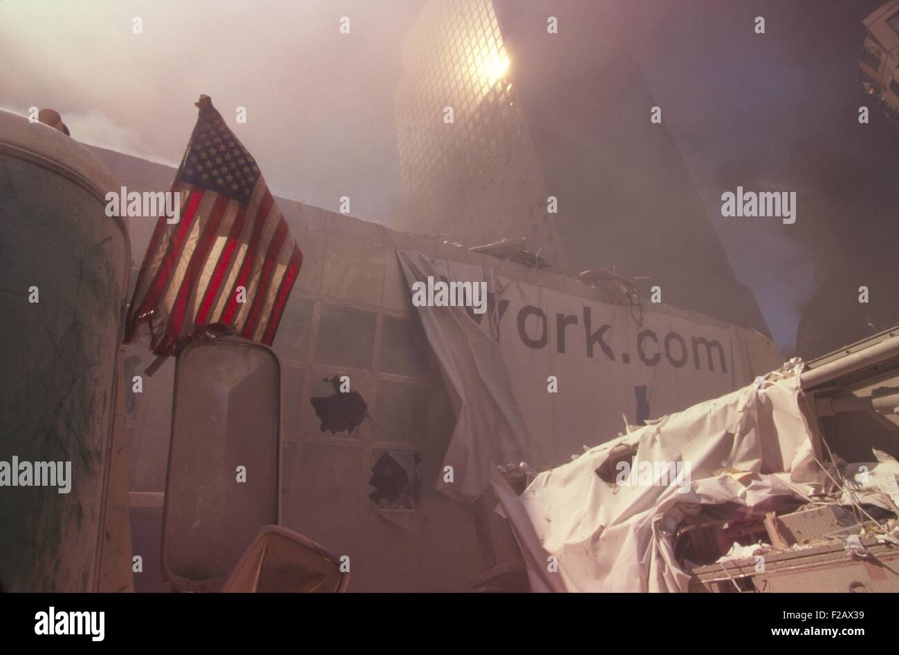 Amerikanische Flagge in den Trümmern des World Trade Centers nach 9 / 11 Terroranschläge gepflanzt. Die nächste Struktur ist eine Fußgängerbrücke über den West Side Highway (West St.), die das WTC mit dem World Financial Center verbunden. New York City, 11. September 2001. Im Hintergrund ist WFC-2. (BSLOC 2015 2 61) Stockfoto