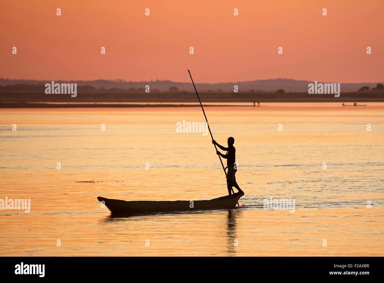 Silhouette der madagassischen Fischer Stechkahn fahren Piroge mit Schiebestange auf Tsiribihina / Tsiribinha Fluss bei Sonnenuntergang, Menabe, Madagaskar Stockfoto