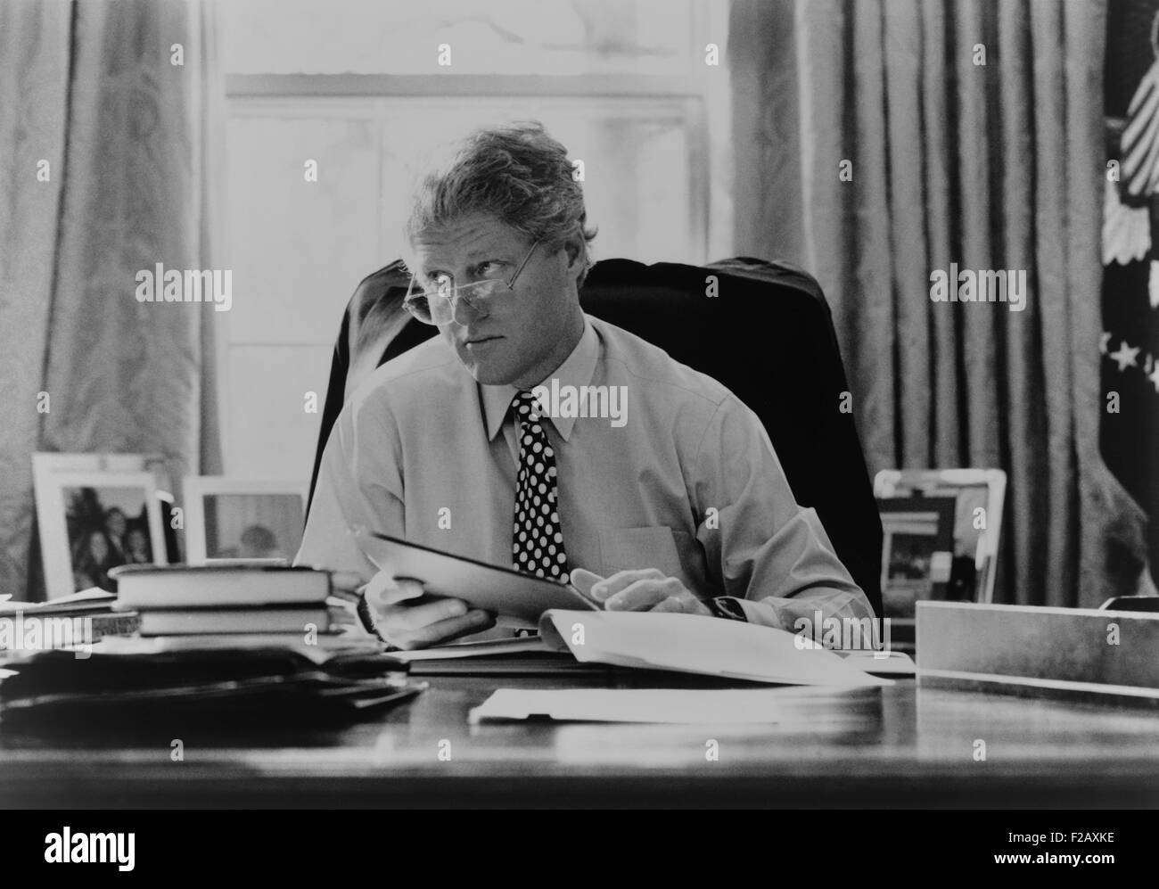 Informelle Porträt von Präsident Bill Clinton an seinem Schreibtisch im Oval Office. 1993. (BSLOC 2015 2 187) Stockfoto