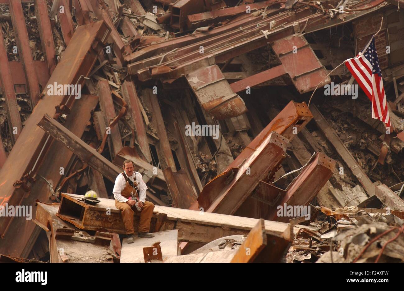 Solo-Feuerwehrmann sitzend auf einem Balken in den Trümmern des World Trade Center, 28. September 2001. New York City, nach dem 11. September 2001 Terroranschläge. (BSLOC 2015 2 109) Stockfoto