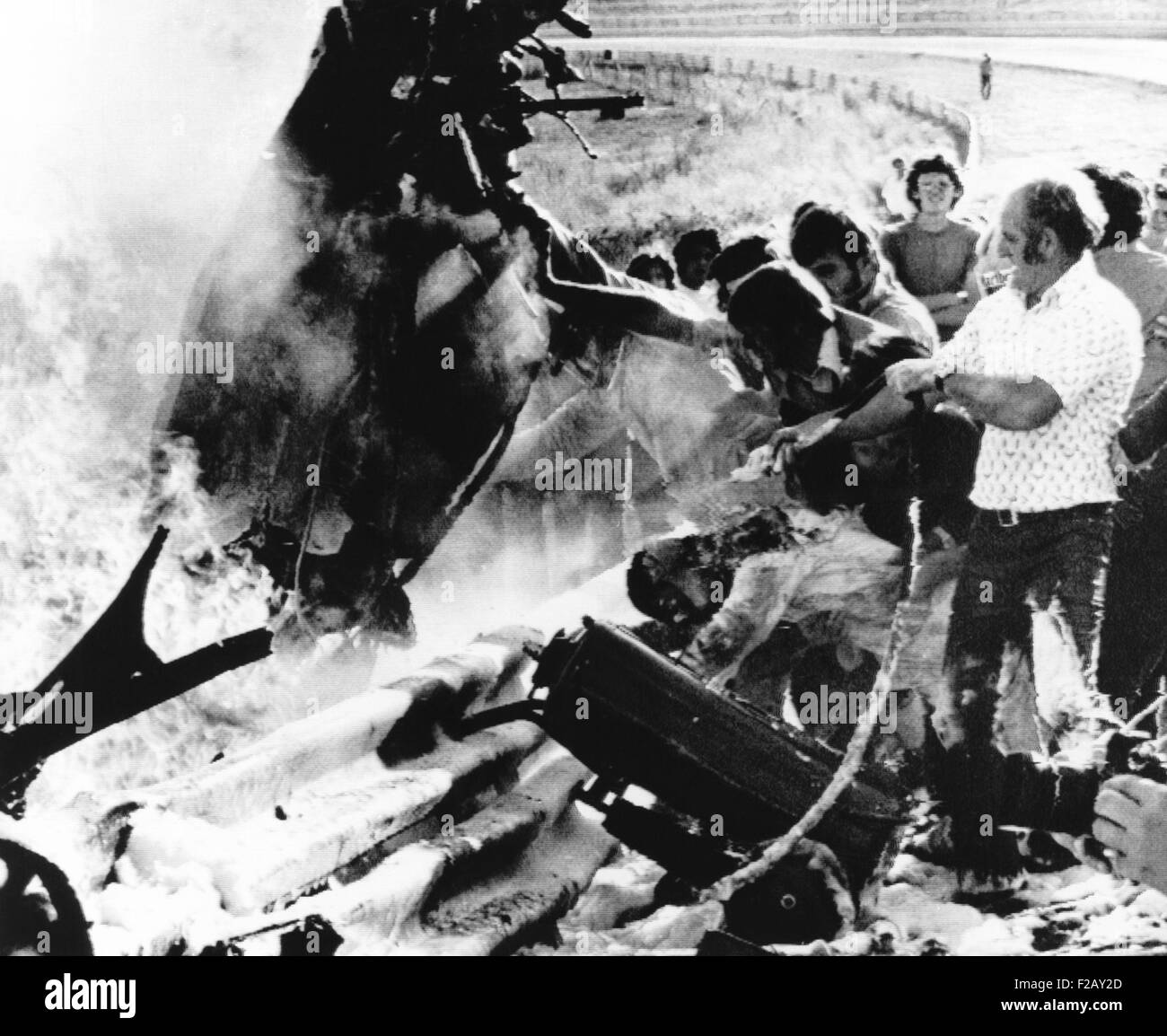 Retter versammeln sich um Peter Revsons zerstörten Rennwagen auf einer Rennstrecke in Johannesburg. 22. März 1974. Revson, 35, starb auf dem Weg ins Krankenhaus. (CSU 2015 9 914) Stockfoto