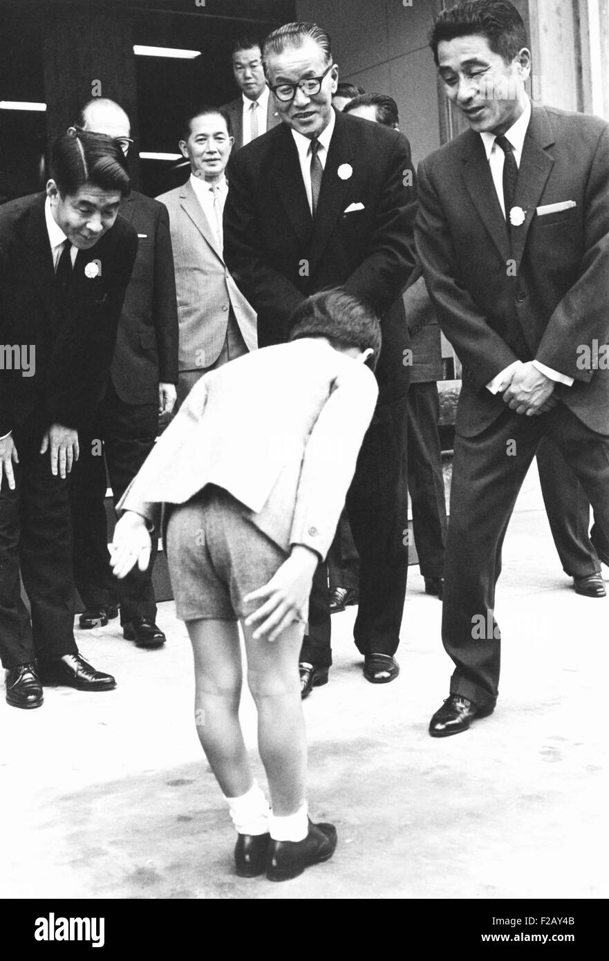 Prinz Hiro verneigt sich vor Orie Kitajima (Mitte), Präsident von Dainippon Printing Company. 11. Oktober 1967. Der Prinz inspiziert riesige Maschinen und Druckverfahren für seine soziale Studien in der Schule (CSU 2015 9 864) Stockfoto