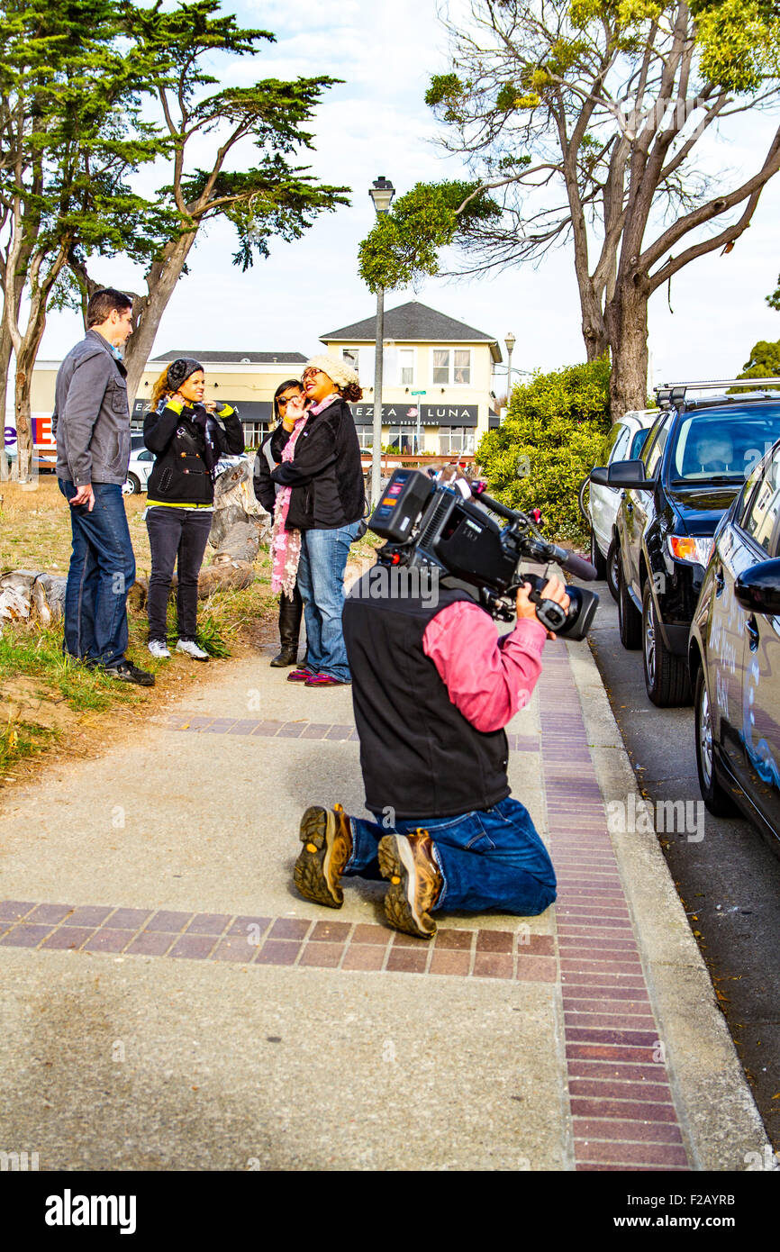 Ein Videofilmer immer den Schuss während Fans Chat im Hintergrund beim 2014 Mavericks Wettbewerb in Half Moon Bay, Kalifornien Stockfoto