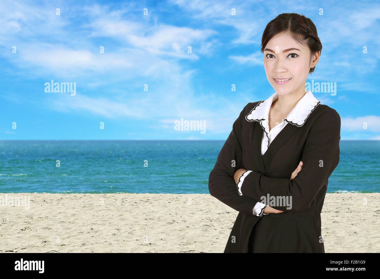 Geschäftsfrau, verschränkten Armen, mit Meer, Strand und Himmel Hintergrund Stockfoto