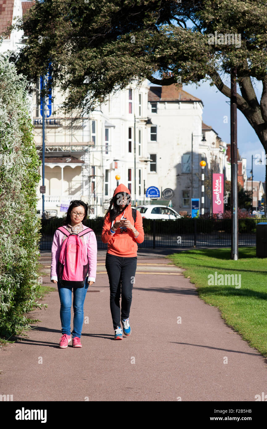 zwei jungen asiatischen Frauen zu Fuß auf Southsea common an einem sonnigen Nachmittag England-Vereinigtes Königreich Stockfoto