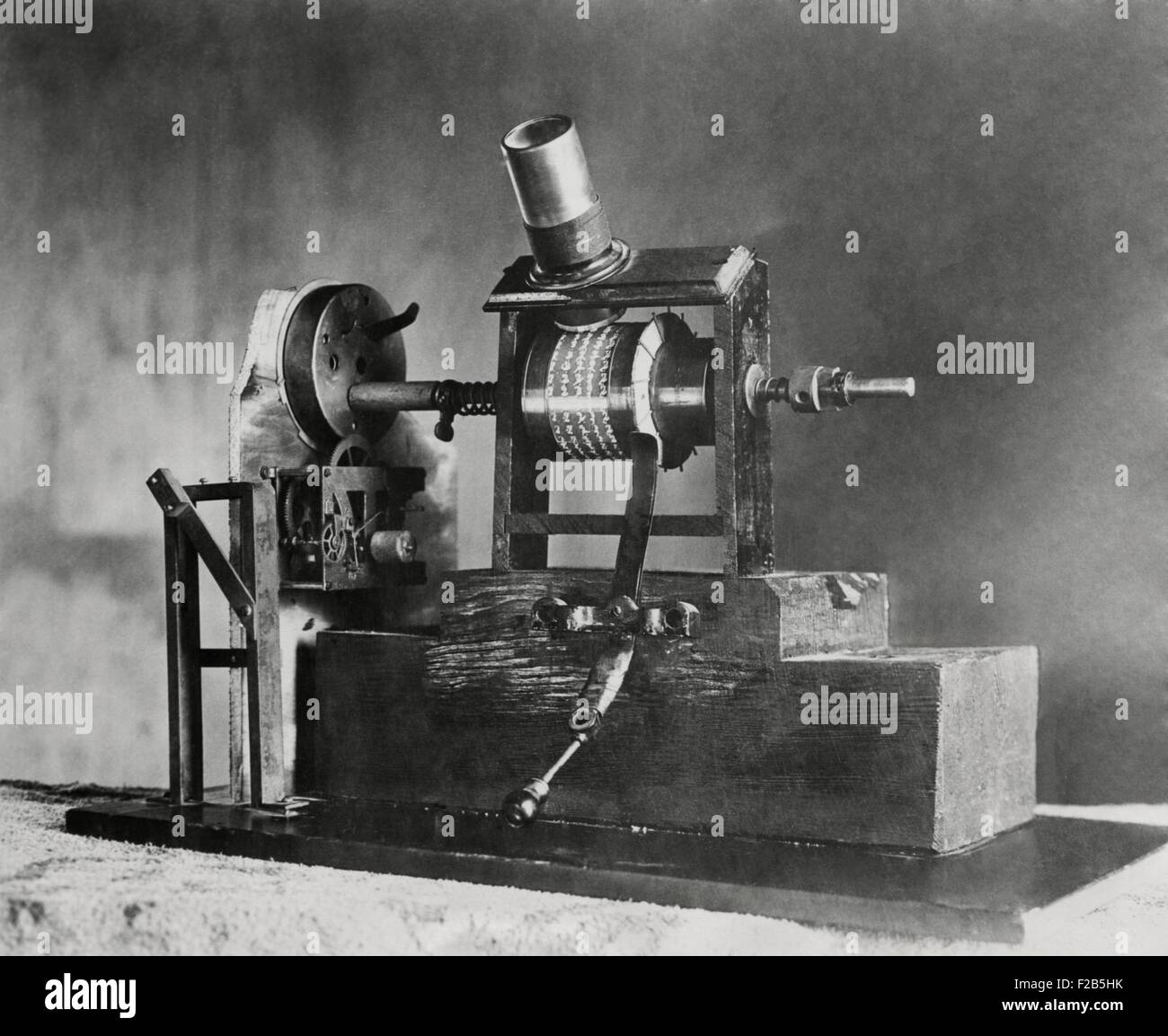 Edisons erste Film Maschine, das Kinetoskop, war ein "Talkie". Im Jahre 1886 wurde das Uhrwerk einer Welle verursacht die kleinen Bilder scheinen sich zu bewegen durch die Lupe betrachtet. Gleichzeitig konnte die synchronisierte Sounds aus dem Wachs-Datensatz auf der rechten Seite des Films über Kopfhörer hören. -(BSLOC 2014 17 118) Stockfoto