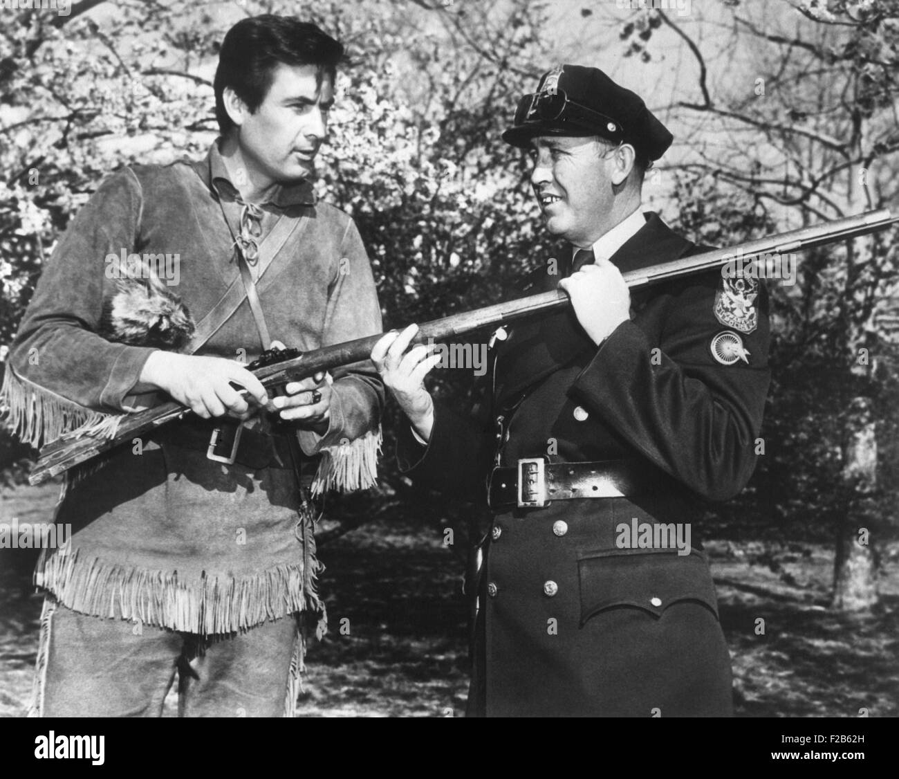 Schauspieler Fess Parker in der Frontier-Kostüm von Davy Crocket mit einem weißen Haus Polizisten. Parker spielte in dem Disney-Film und TV-Serien, "Davy Crockett, König der wilden Grenze". Ca. April 1955. -(BSLOC 2014 16 163) Stockfoto