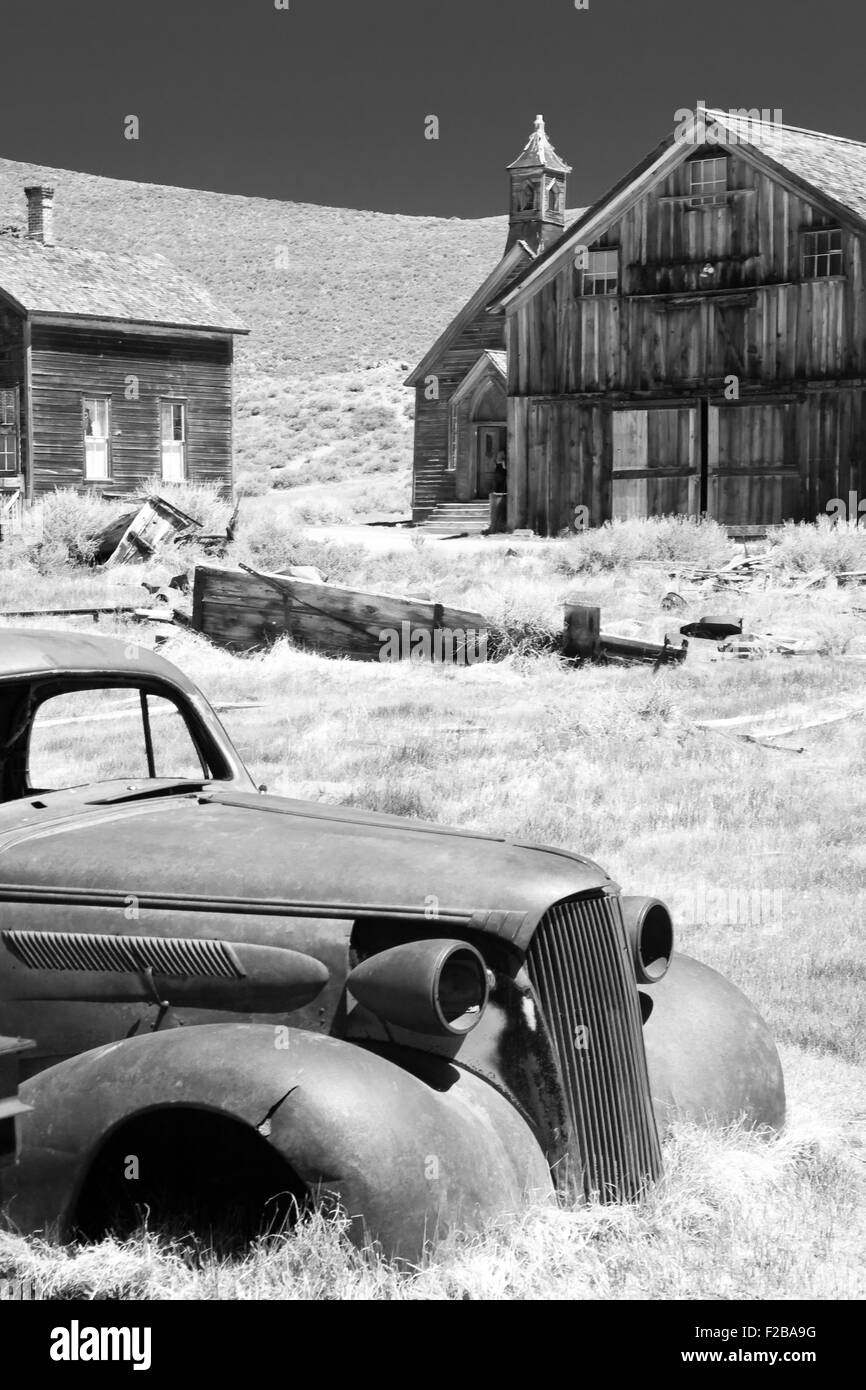 Auto und historische Holzbauten in Bodie State Historic Park einer kalifornischen Goldminen-Geisterstadt aufgegeben. Stockfoto