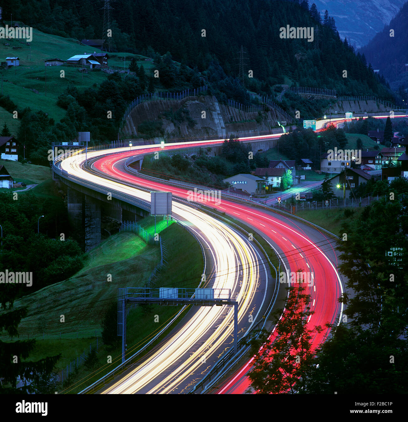 Nachtansicht von Lichtspuren auf der Schweizer A2 Autobahn in der Nähe von Wassen, Blick nach Süden in Richtung St. Gotthard-Tunnel. Stockfoto
