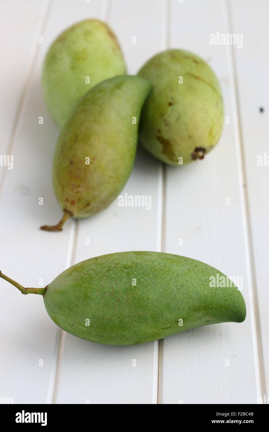 Grünen Mangos auf weißem Holz Stockfoto