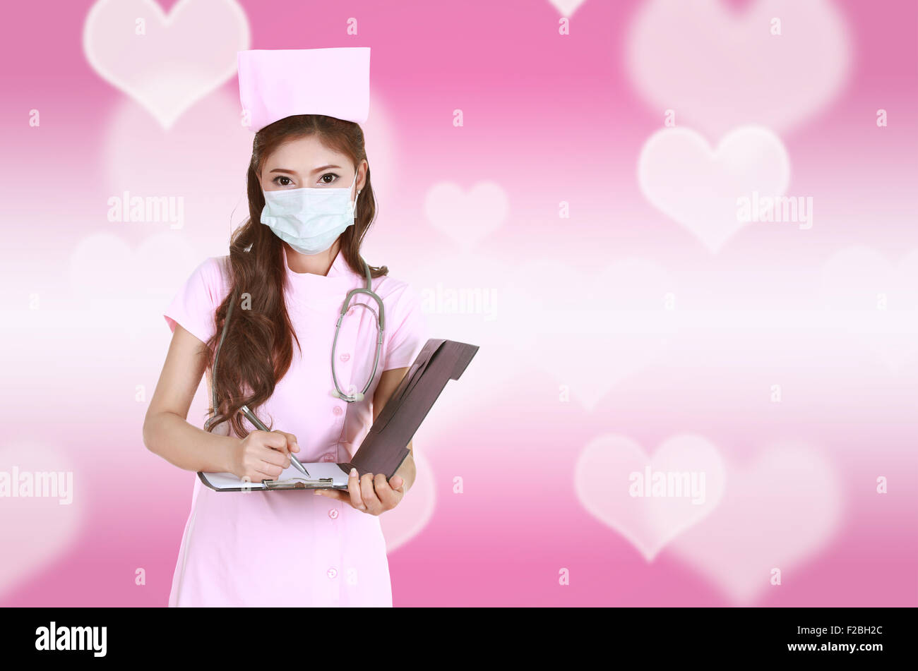 Krankenschwester schreiben Zwischenablage mit Herz Hintergrund Stockfoto