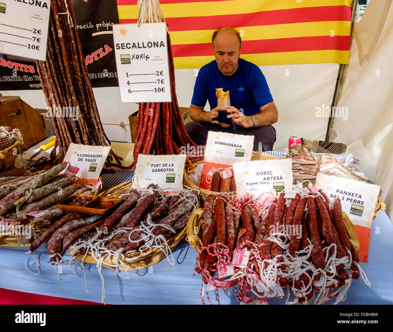 Flohmarkt-Händler und Würstchen für den Verkauf auf einem Marktstand in der Rambla del Poblenou, Barcelona, Katalonien, Spanien Stockfoto