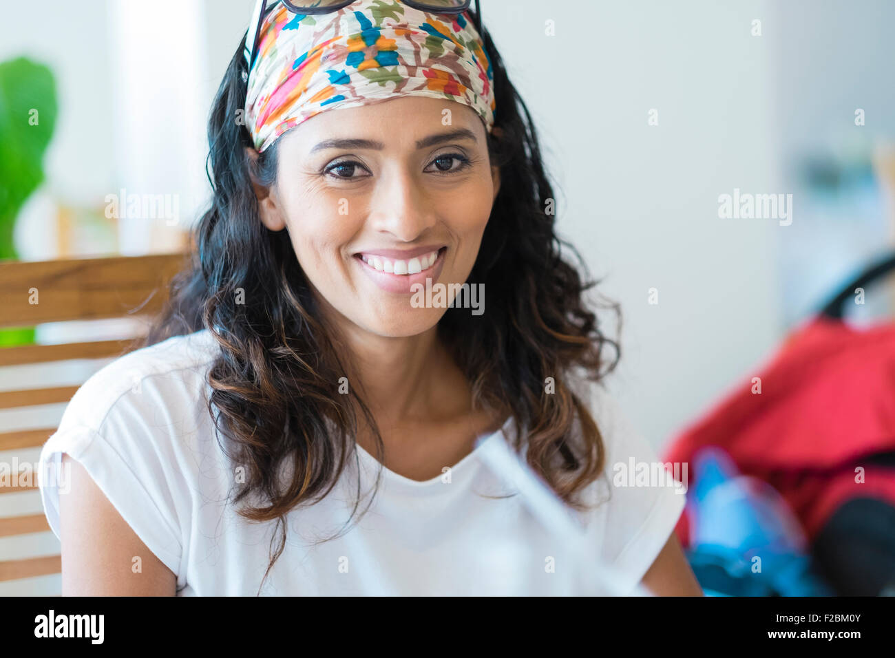Schöne spanische Frau sitzt am Tisch lächelnd Stockfoto