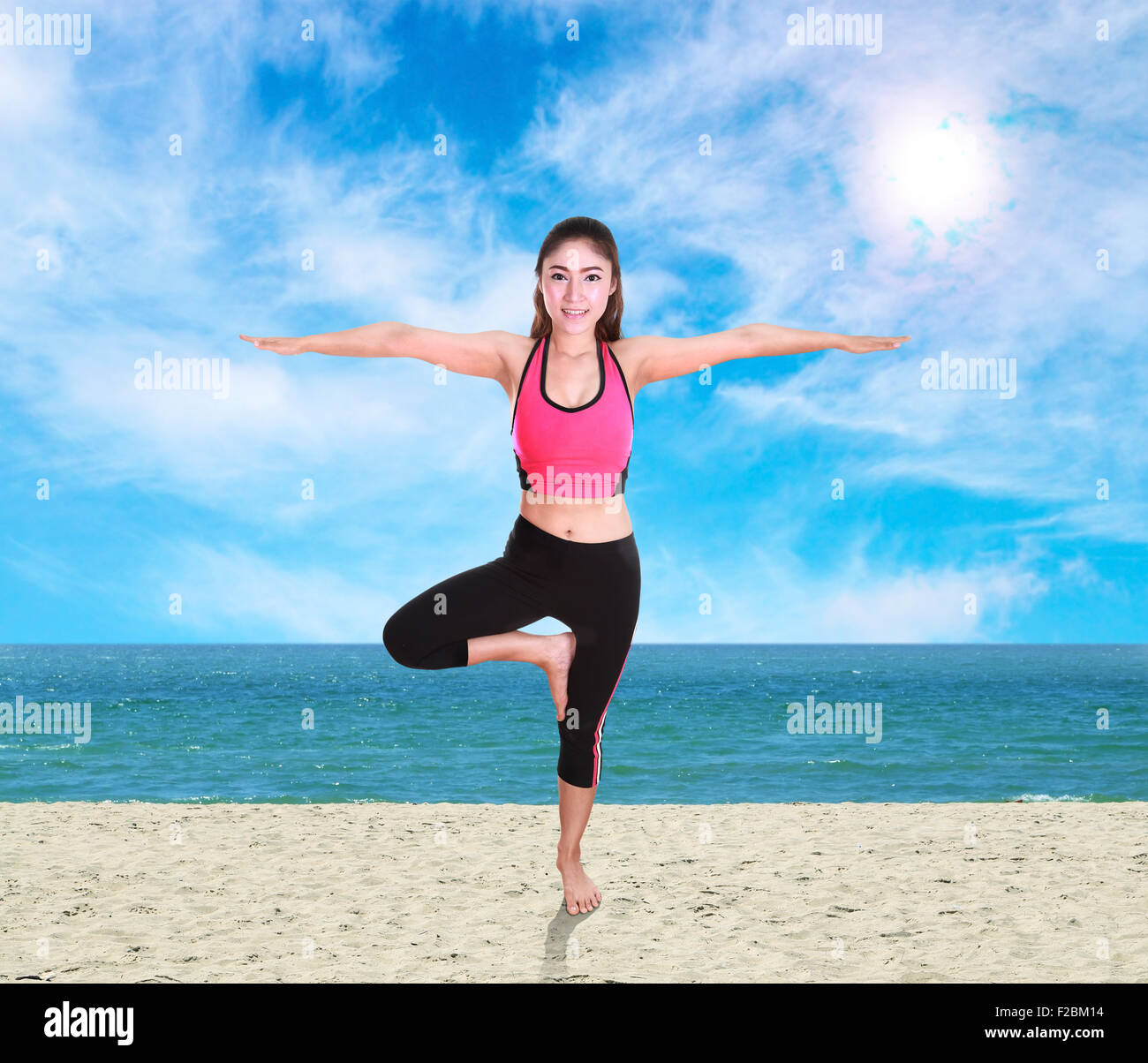 Junge Frau, die Yoga Übung am Strand Stockfoto