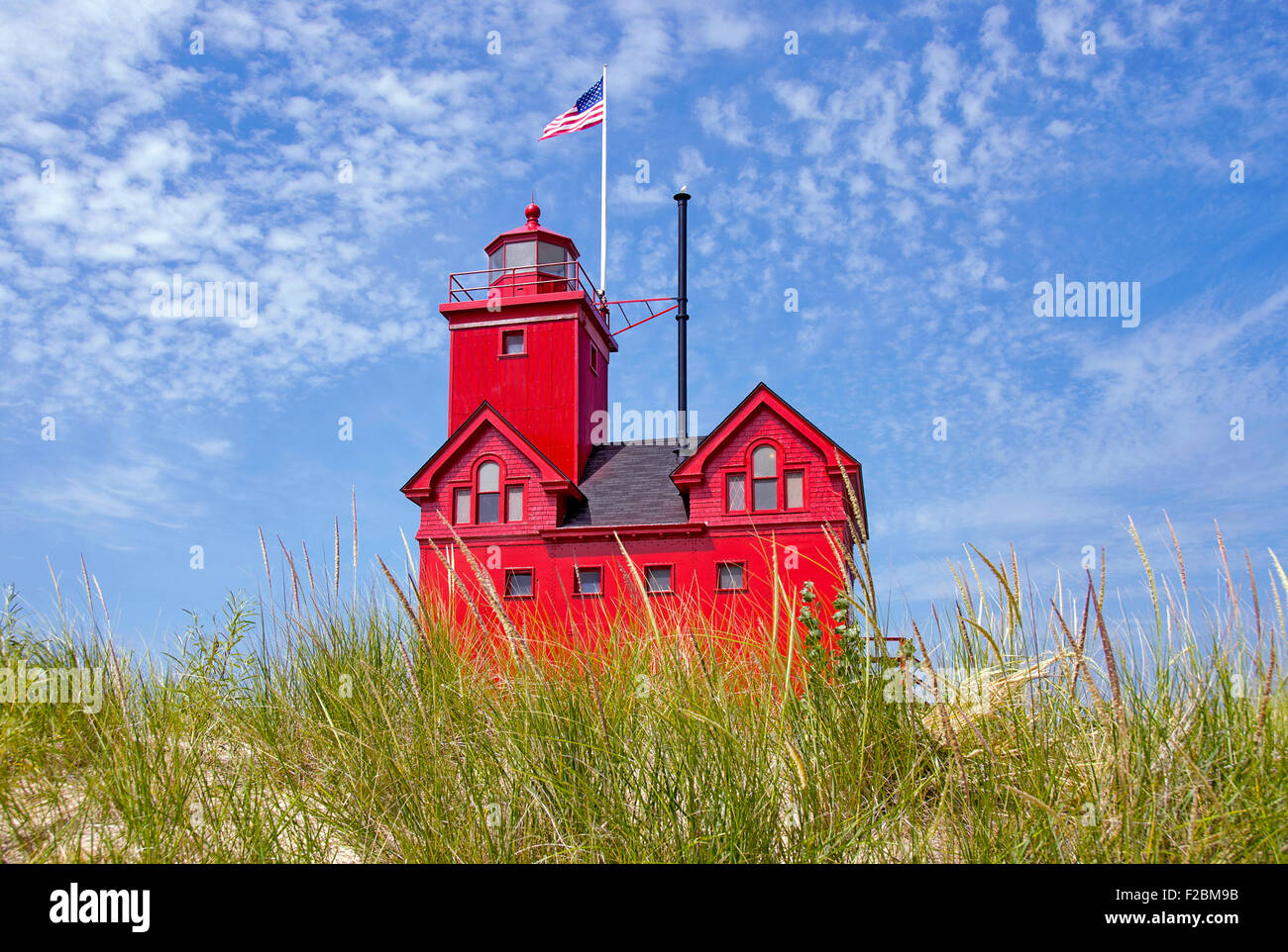 Leuchtend rote Leuchtturm in Holland, Michigan im Dünengras. Stockfoto