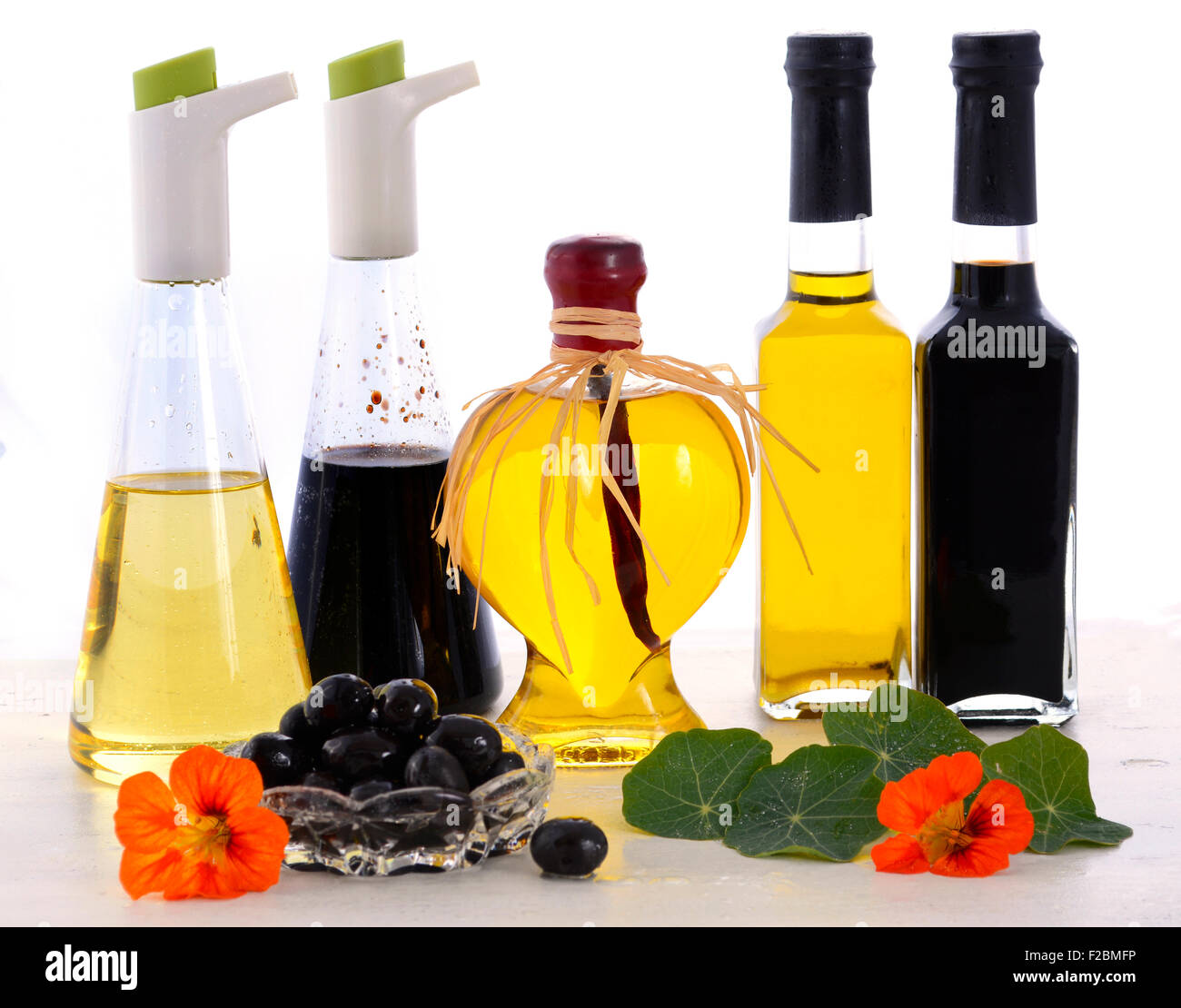 Salat-Dressing mit Ölen, Oliven und Essig auf weißer Holztisch. Stockfoto