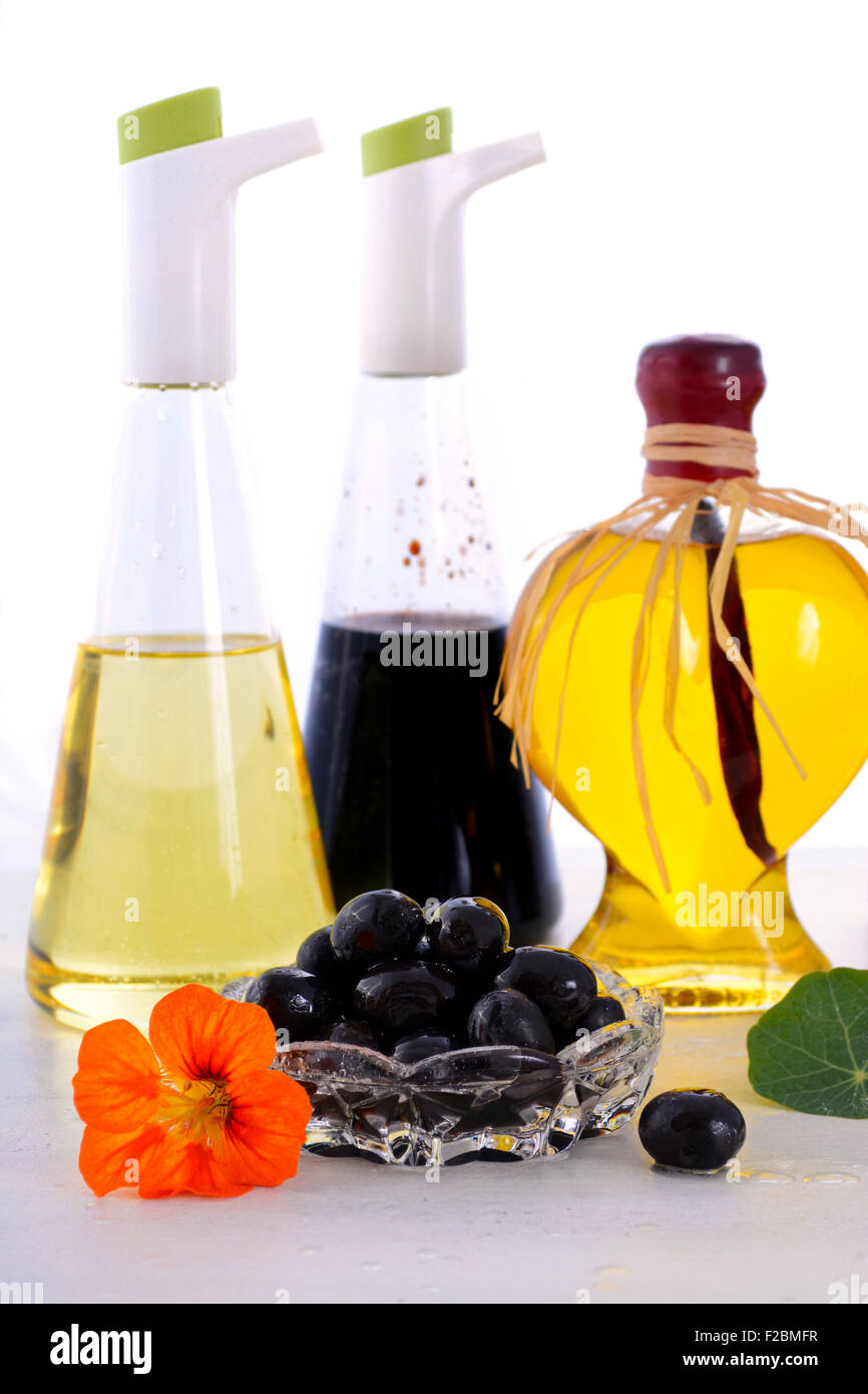 Salat-Dressing mit Ölen, Oliven und Essig auf weißer Holztisch. Stockfoto