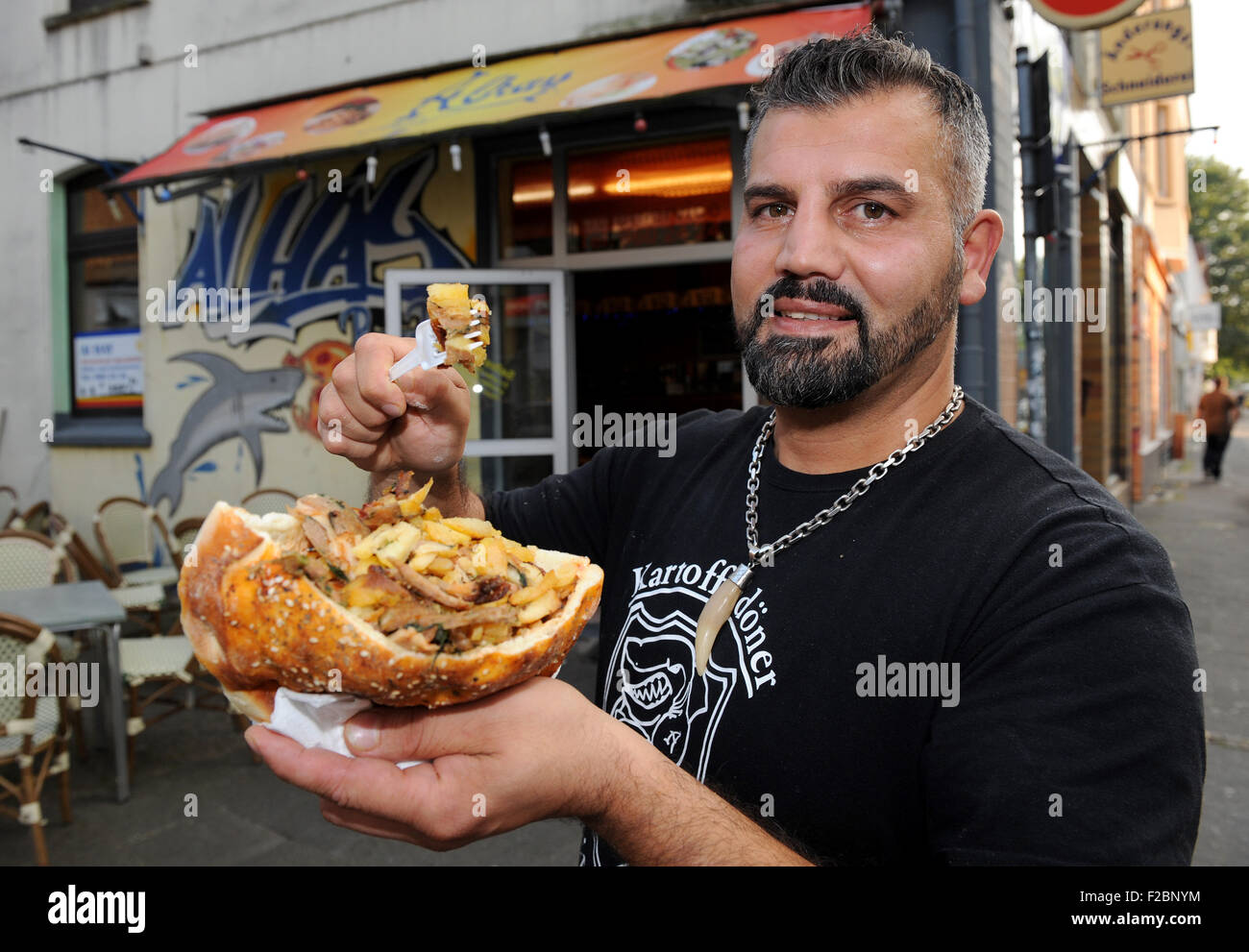 Oldenburg, Deutschland. 11. September, 2015. Libanesische Küche Stall Besitzer Hani Alhay präsentiert seine Kartoffel Döner vor seiner Garküche in Oldenburg, Deutschland, 11. September 2015. Inspiriert durch ein Plakat der islamfeindlichen Gruppe "Pegida", die "Kartoffel Statt Döner" liest ("Kartoffeln statt Döner"), Alhay erstellt einen Döner mit Fleisch und Kartoffeln. Foto: Ingo Wagner/Dpa/Alamy Live News Stockfoto