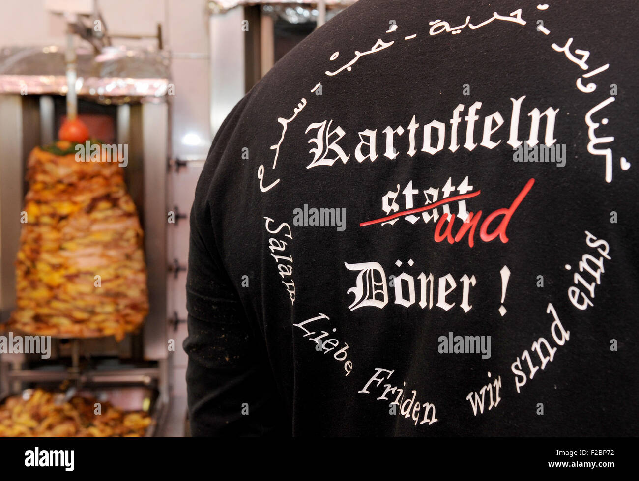 Oldenburg, Deutschland. 11. September, 2015. Libanesische Küche Stall Inhaber Hani Alhay zeigt sein Hemd, das liest "Kartoffeln Und Döner" ("Kartoffeln und Döner") in einem Lebensmittel stall in Oldenburg, Deutschland, 11. September 2015. Inspiriert durch ein Plakat der islamfeindlichen Gruppe "Pegida", die "Kartoffel Statt Döner" liest ("Kartoffeln statt Döner"), Alhay erstellt einen Döner mit Fleisch und Kartoffeln. Foto: Ingo Wagner/Dpa/Alamy Live News Stockfoto