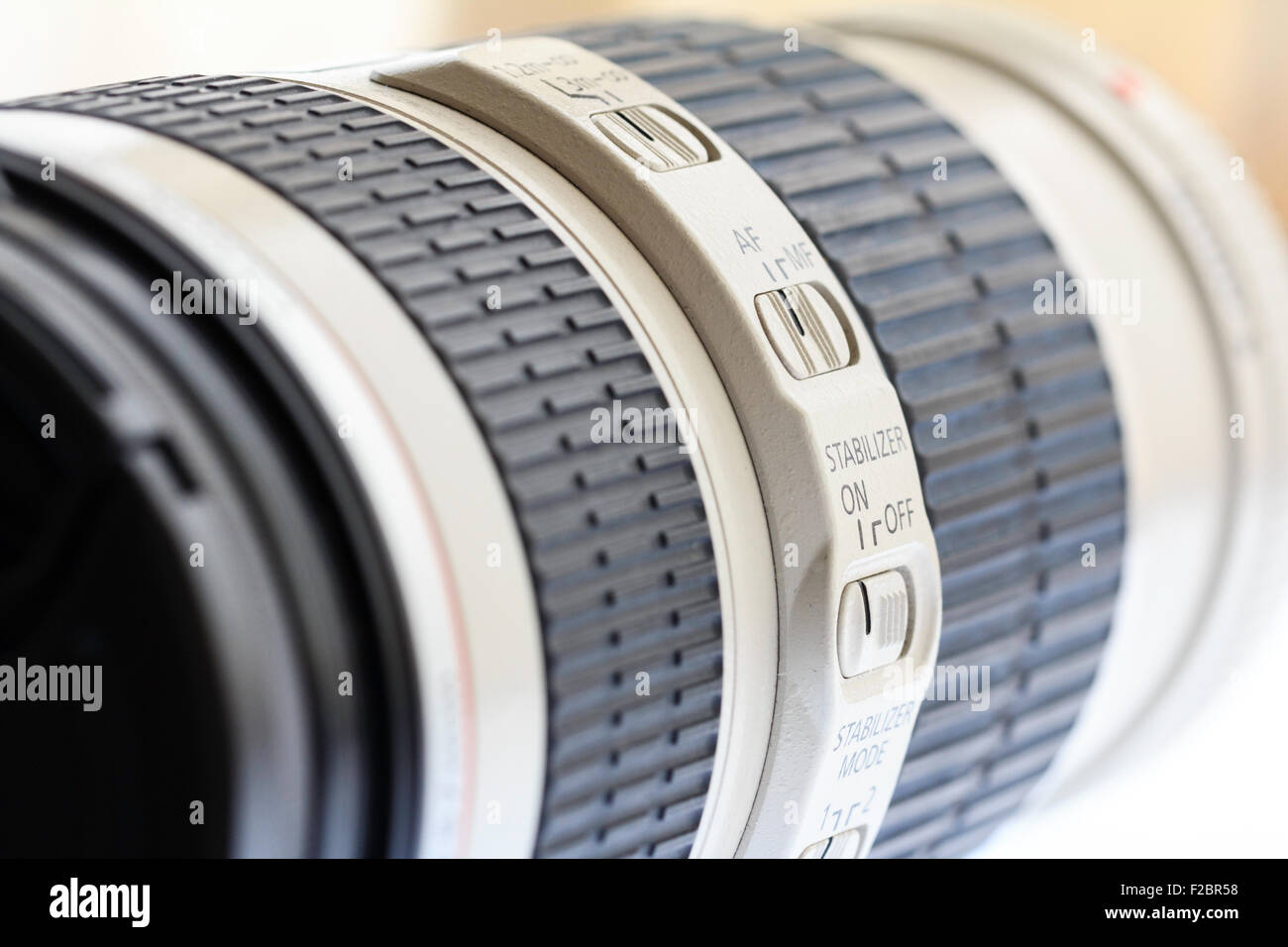 Nahaufnahme von Canon L-Objektiv, 70-200 mm F4 zeigt das Bedienfeld an der Seite des Objektiv mit Bildstabilisator und Modus zu wechseln, und schwarzem Gummigriff. Stockfoto