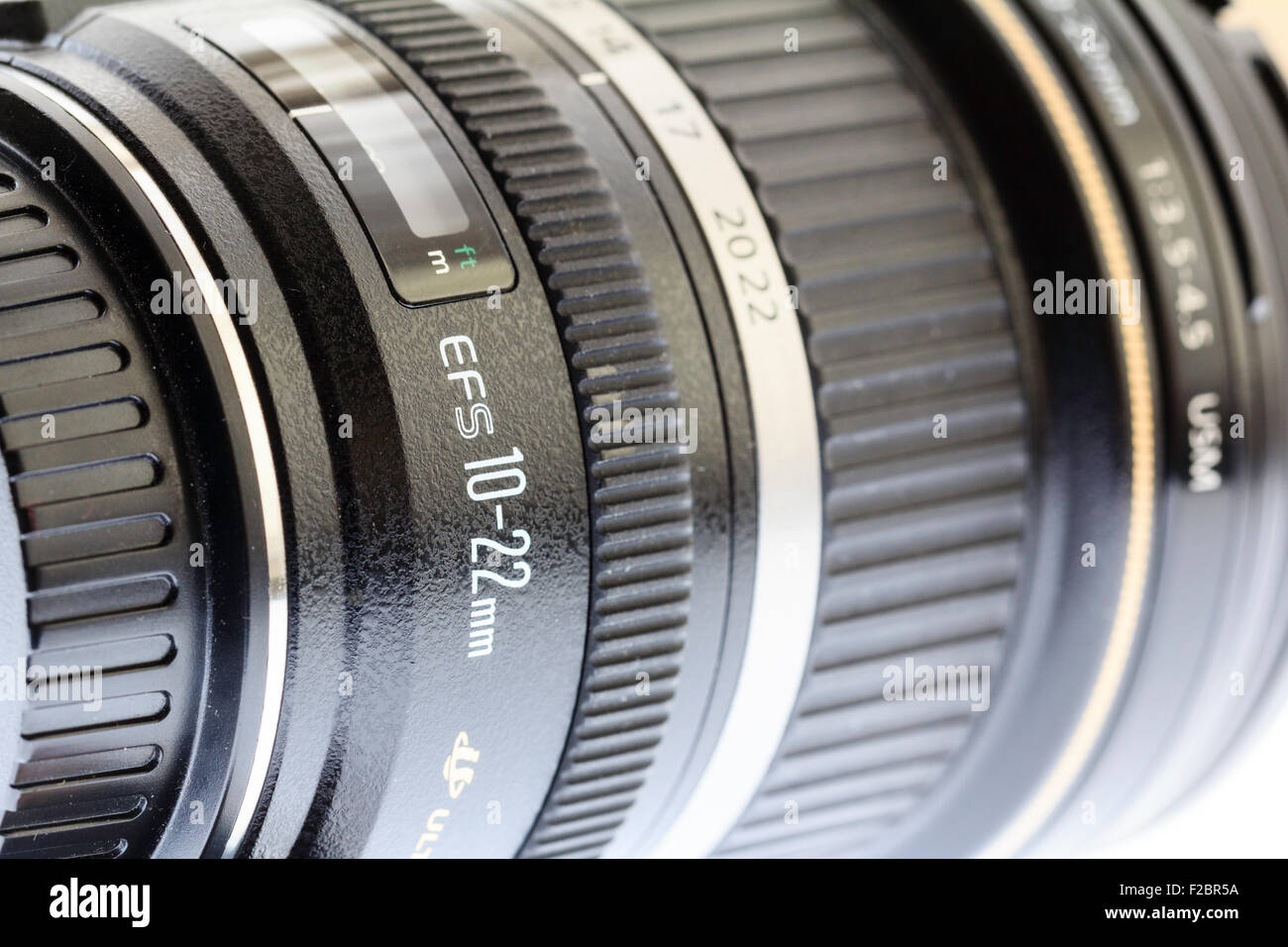 Nahaufnahme Blick entlang der fotografischen Canon Objektiv 10-22 mm mit dem Namen des Objektivs an der Seite des Objektivtubus und schwarzem Gummigriff. Stockfoto