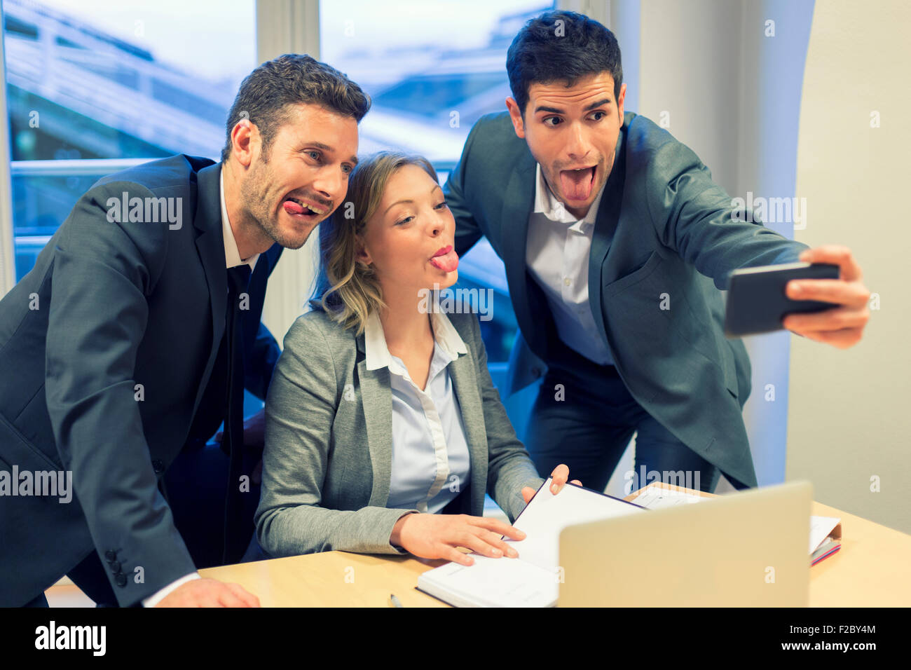 Porträt von drei Geschäftsleute Grimassen während der Einnahme ein Selbstporträt mit smartphone Stockfoto
