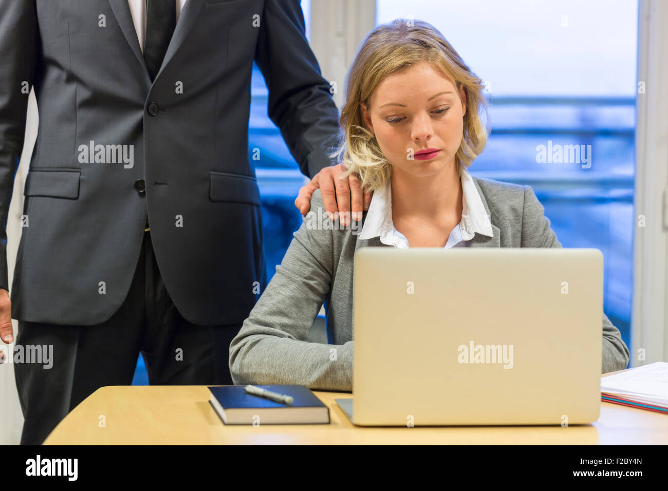 deprimiert Geschäftsfrau mit Laptop in ihrem Büro mit Kollegen Stockfoto