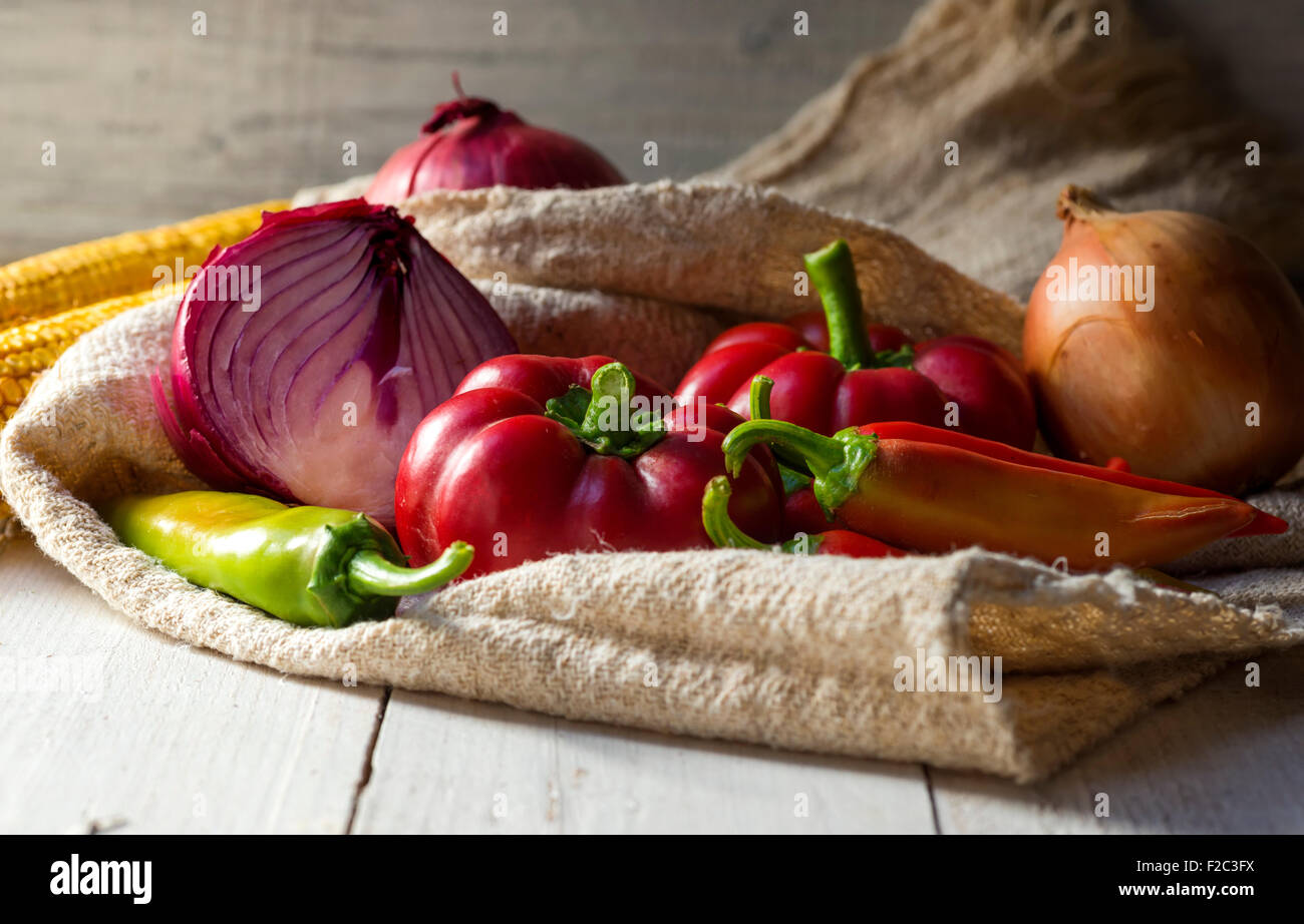 Zwiebel, Pfeffer und Paprika auf Holztisch Stockfoto