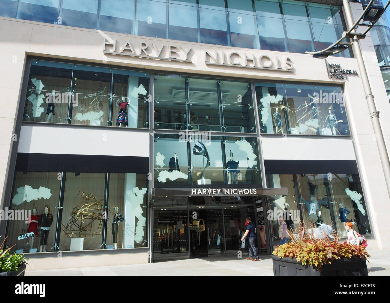 Der modische Designer Harvey Nichols in New Cathedral Street im Stadtzentrum von Manchester, UK, mit blauem Himmel hinter aufbewahren. Stockfoto