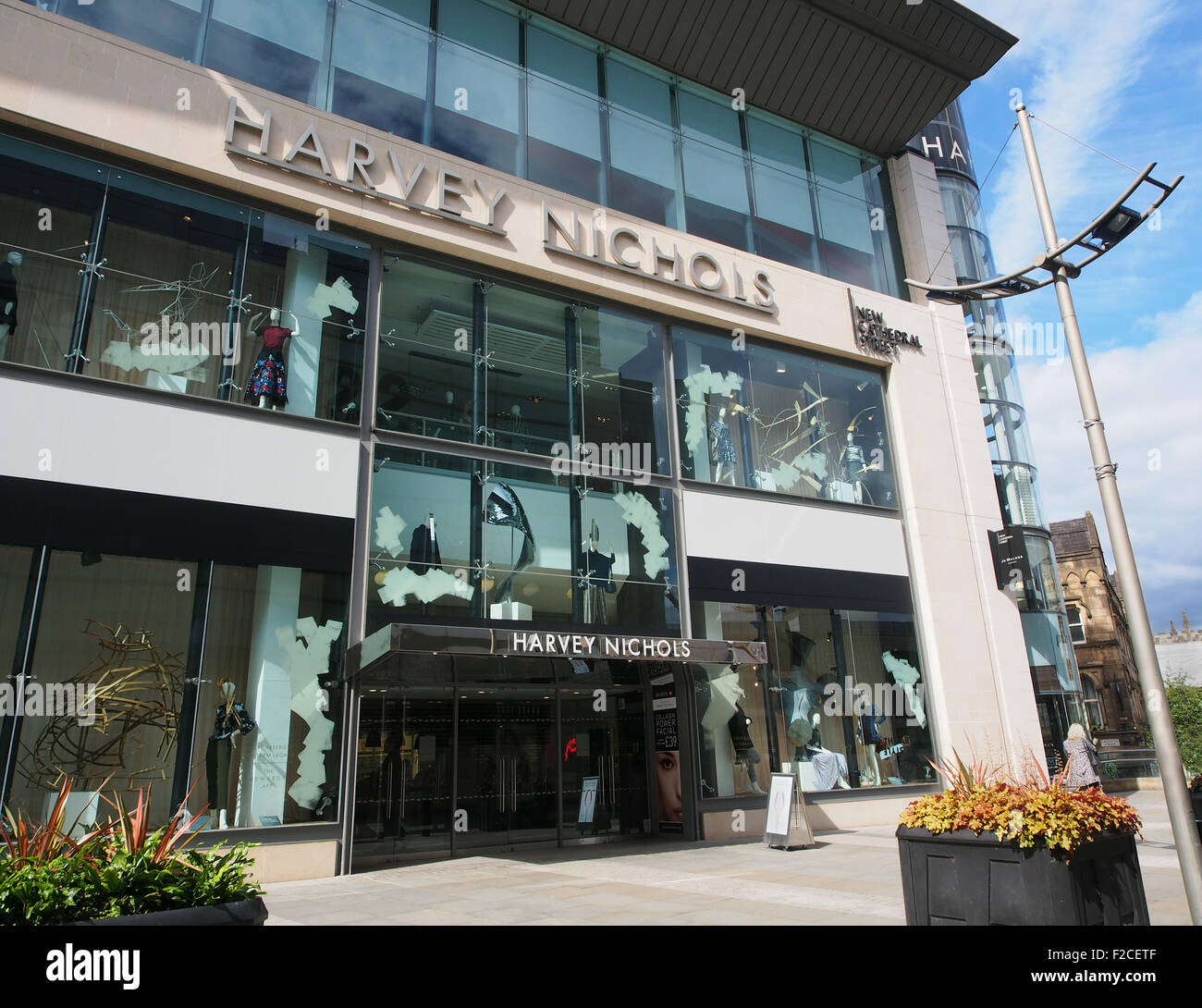 Der modische Designer Harvey Nichols in New Cathedral Street im Stadtzentrum von Manchester, UK, mit blauem Himmel hinter aufbewahren. Stockfoto