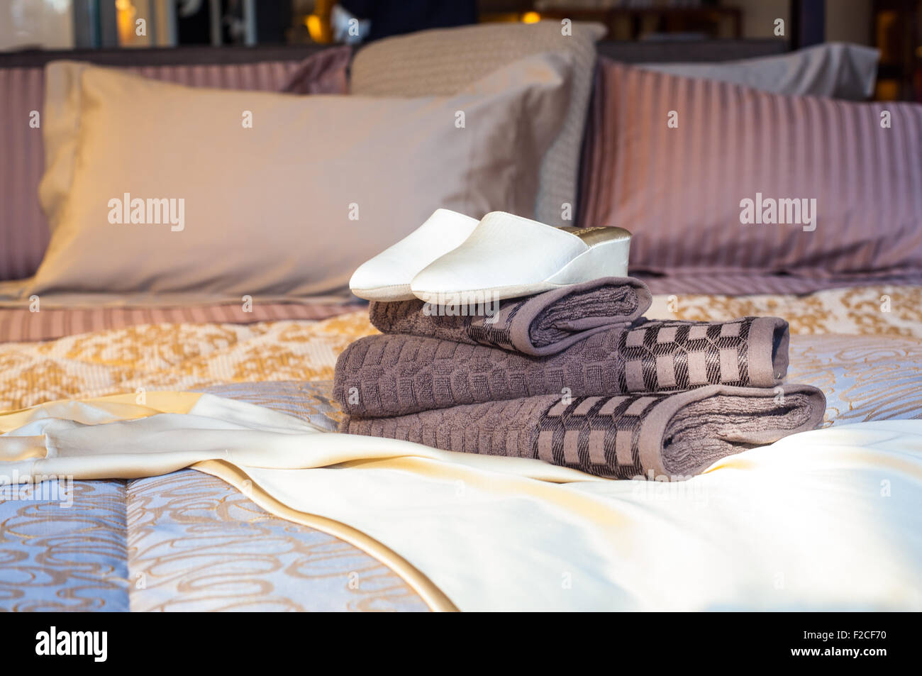 Weiße Frauen Hausschuhe auf den Handtüchern im Bett Stockfoto