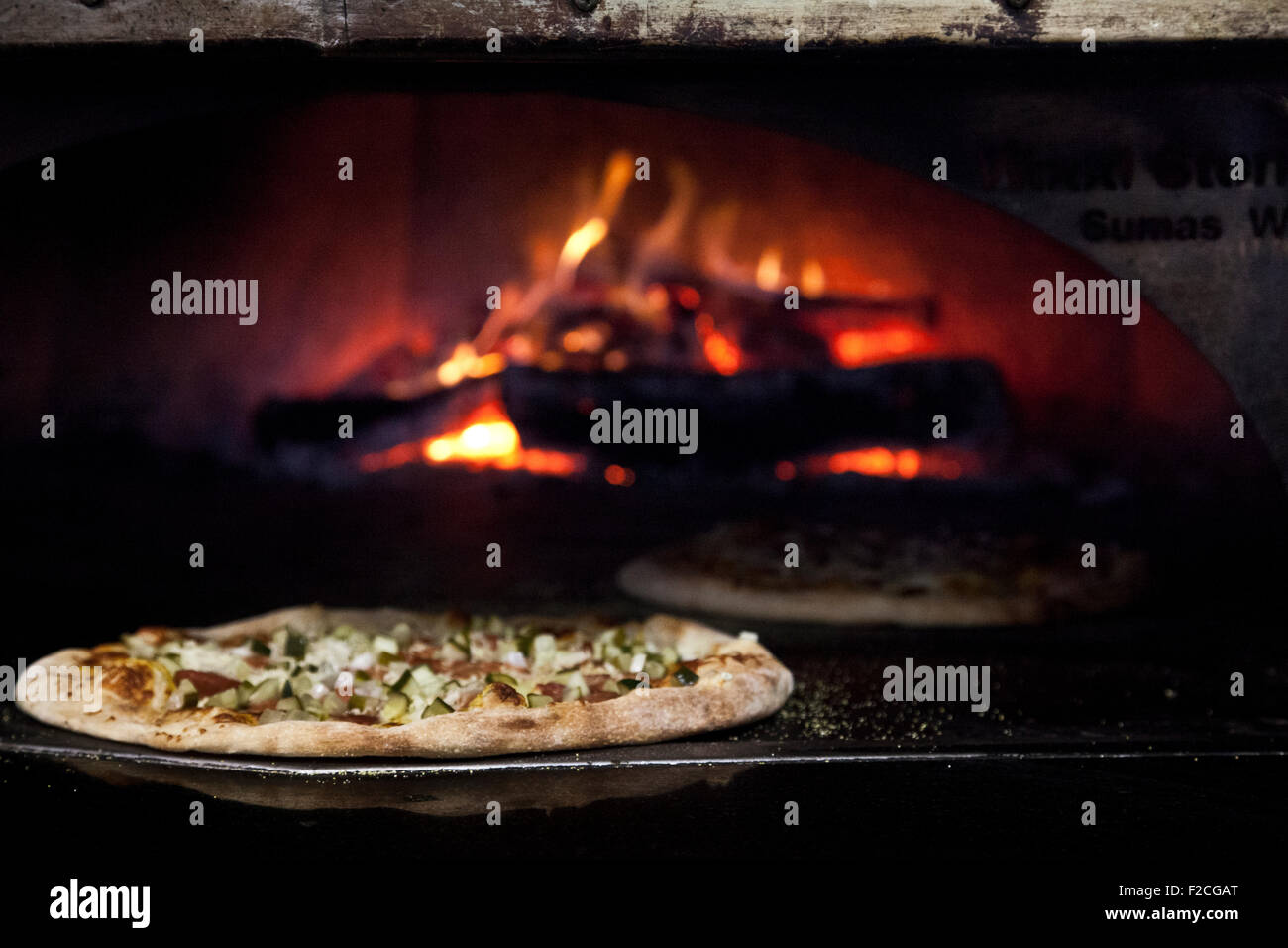 Sausage Pizza mit Mozzarella in einem Holzofen Stockfoto