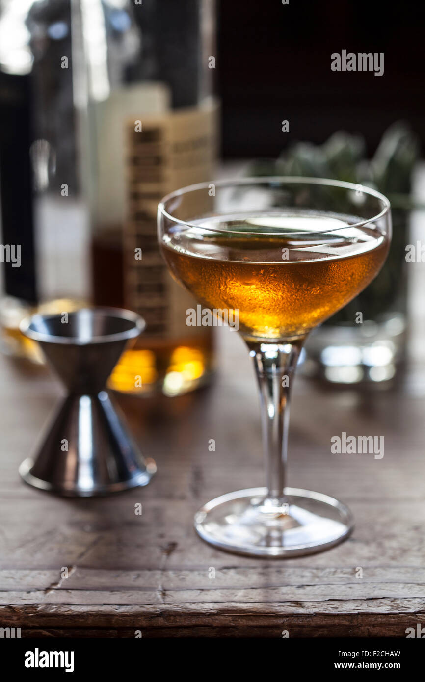 gekühlte Bernstein cocktail in stemmed Glas auf rustikalen Holztisch Stockfoto