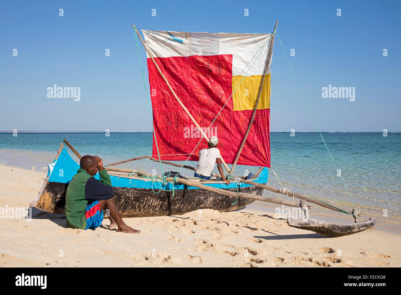Zwei Fischer mit traditionellen Piroge mit Segel am Strand von Nosy Ve, Madagaskar, Südostafrika Stockfoto