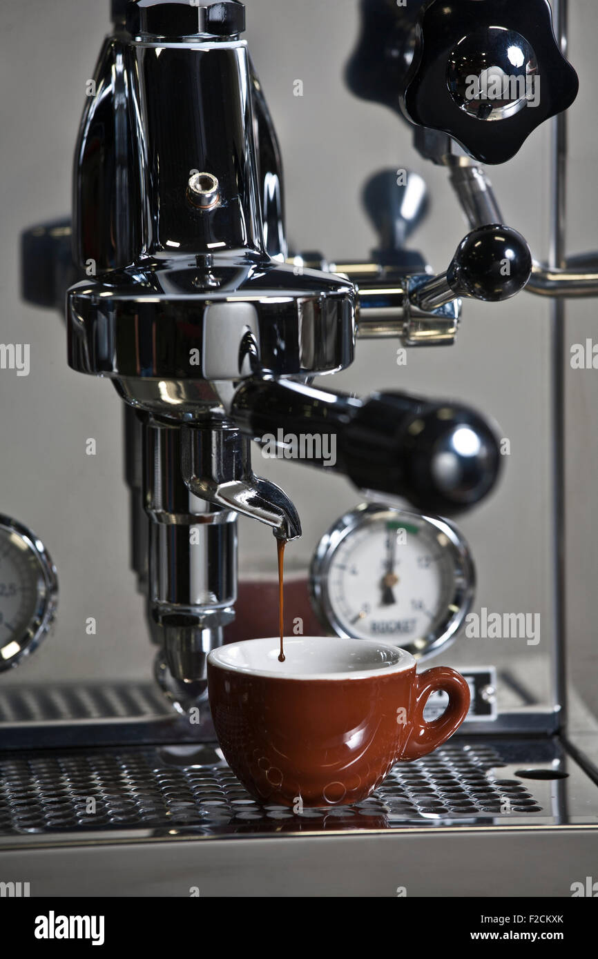 Edelstahl-Espresso-Maschine in Aktion mit braunen Espressotasse Stockfoto