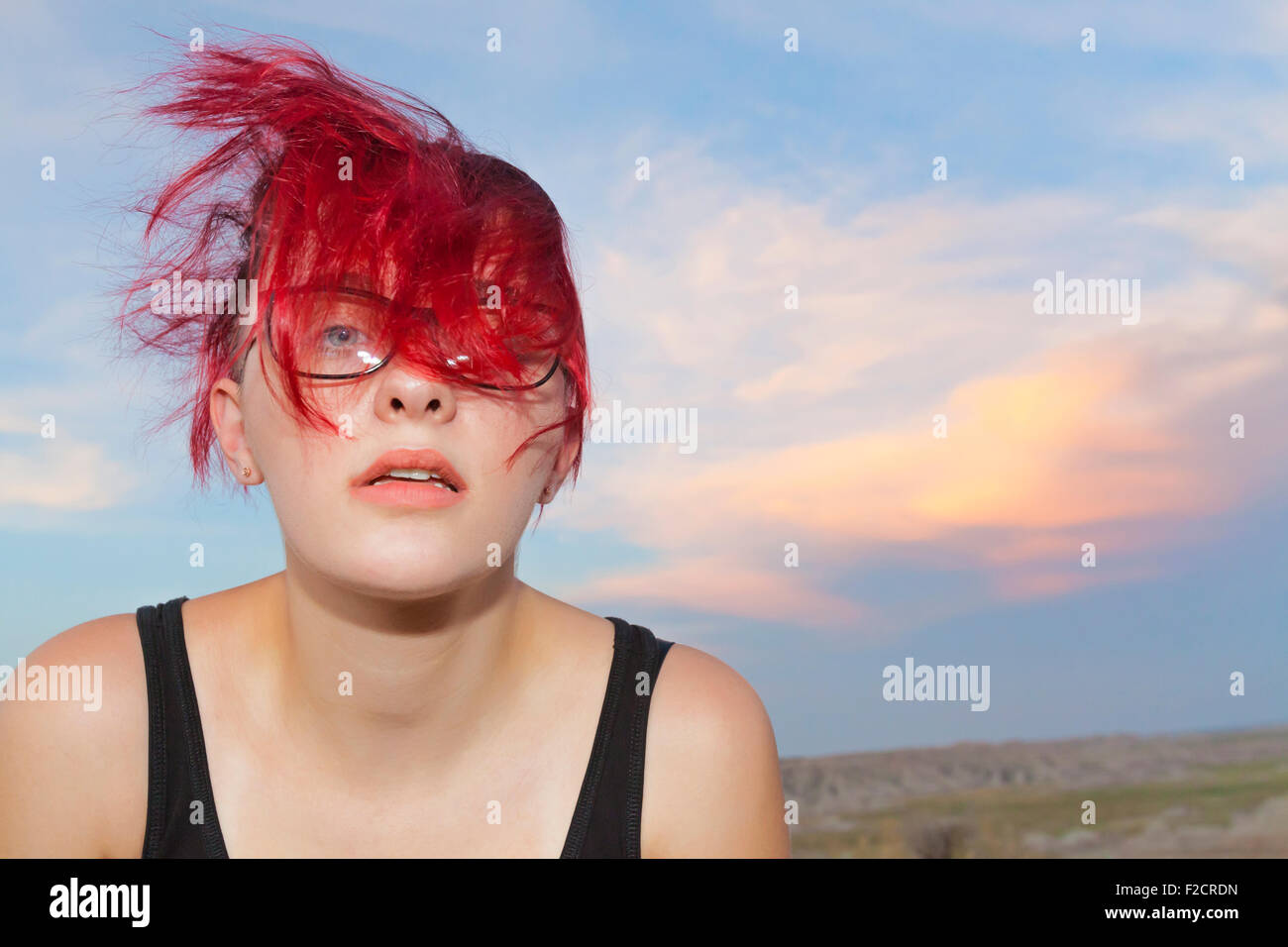 Eine attraktive junge Frau posiert mit nachdenklichen, ernst und albern Ausdrücke im Freien vor einem blauen Himmel. Stockfoto