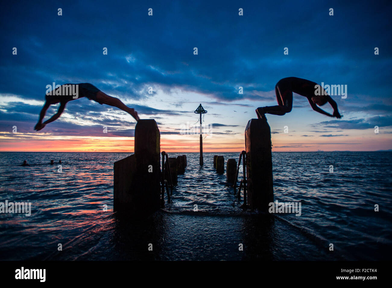 Aberystwyth, Wales, Großbritannien. 16. September 2015. UK-Wetter: Studenten amüsieren sich in der Silhouette, Tauchen und Schwimmen Sie den Tag am Meer Steg nach Sonnenuntergang in Aberystwyth Wales Großbritannien am Ende des 'Indian Summer' feine September Sonnenschein an der Westküste von Wales Bildnachweis: Keith Morris/Alamy Live News Stockfoto