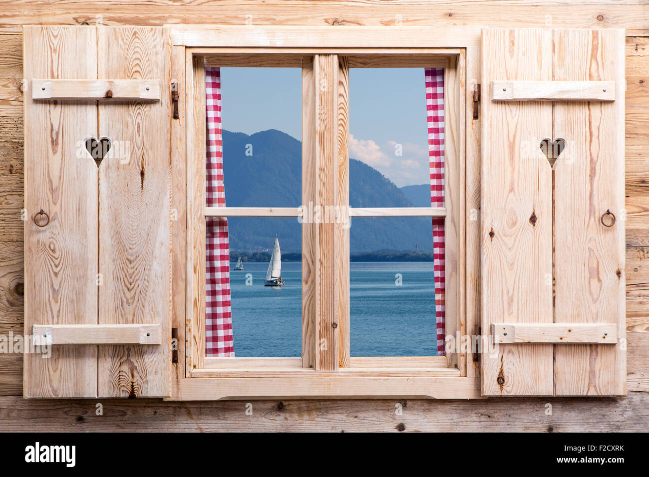 Holzfenster mit einem See und die Berge als Reflexionen Stockfoto