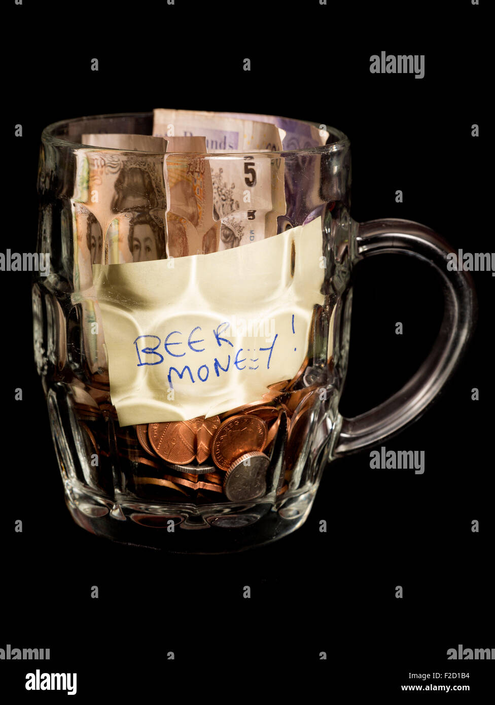 Bier-Ersparnisse in ein Pint Glas auf schwarzem Hintergrund Stockfoto