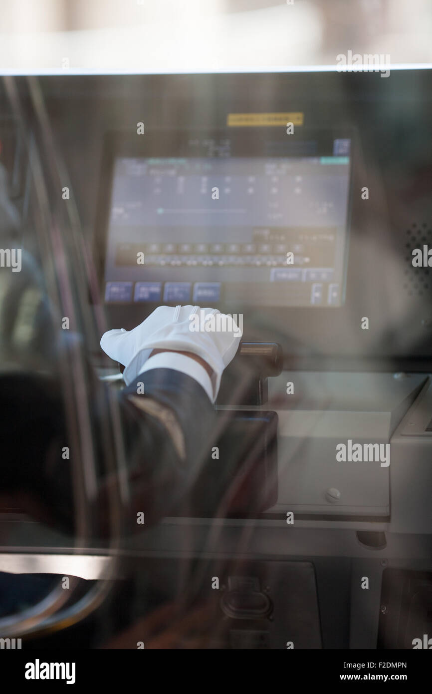 Blick durchs Glas Zug Fahrer Hand in weißen Handschuhen mit Computer- Stockfoto